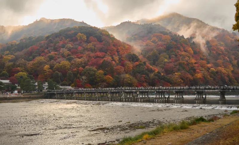 Il ponte Togetsukyō sul fiume ad Arashiyama, con la foschia che sale dai monti in autunno.